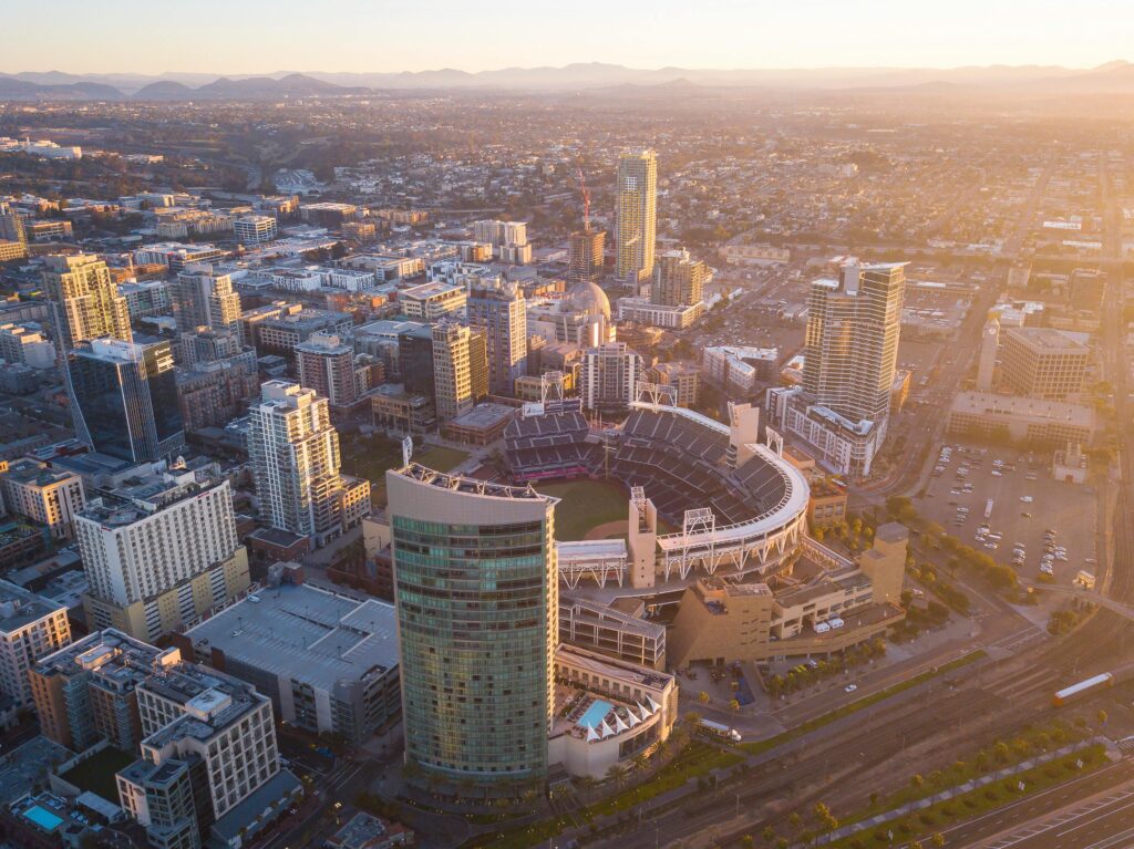 Aerial view of downtown San Diego featuring Petco Park and surrounding cityscape at sunset.